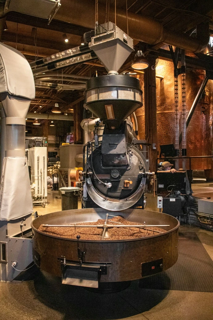 Coffee beans are being roasted in a large machine.